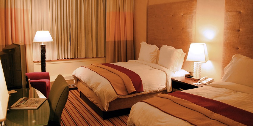A lavish executive suite room with a view of a river from a glass window.