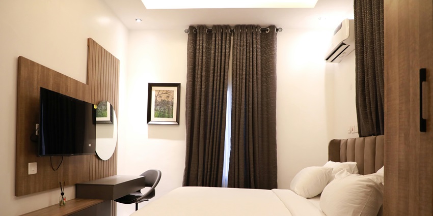 A lavish executive suite room with a view of a river from a glass window