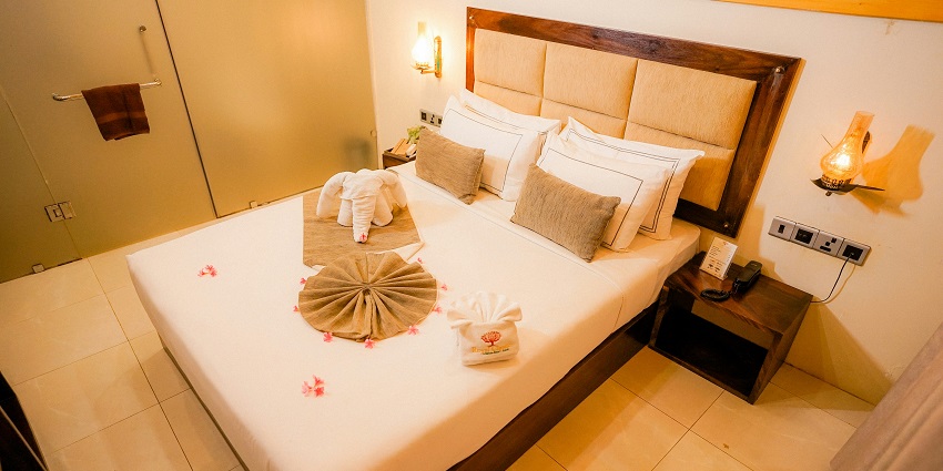 Image of a bed with pillows and towels in a hotel room - best for travellers for staycation