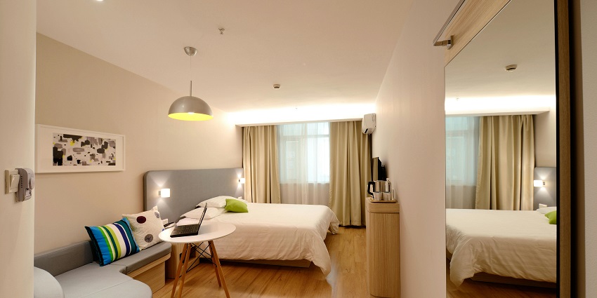 An image showing the elegant interior setup of a hotel bedroom with modern furnishings