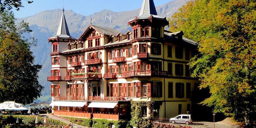 An image of Hotel Giessbach offers stunning views of waterfalls and Lake Brienz.
