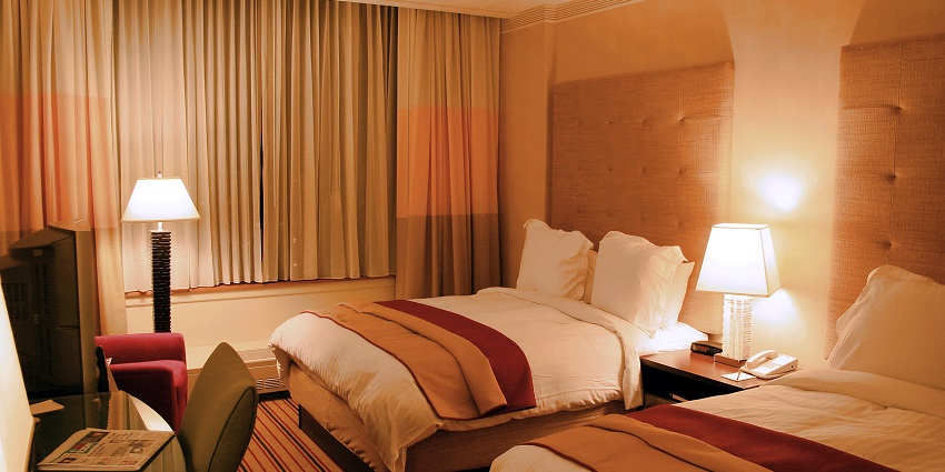 A lavish executive suite room with a view of a river from a glass window.