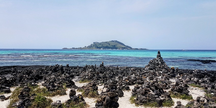 Jeju Island beach with turquoise waters and soft sand.