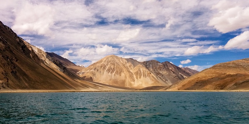 Lake in Ladakh with the bright blue water, sandy shorelines and distant mountains