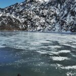 An image of man watching the serene picturesque frozen Changu Lake in Eastern Sikkim.