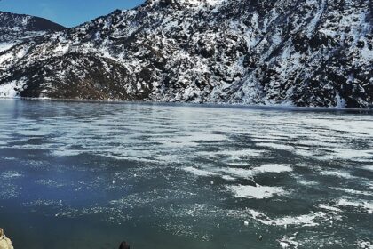 An image of man watching the serene picturesque frozen Changu Lake in Eastern Sikkim.