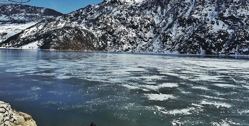 An image of man watching the serene picturesque frozen Changu Lake in Eastern Sikkim.