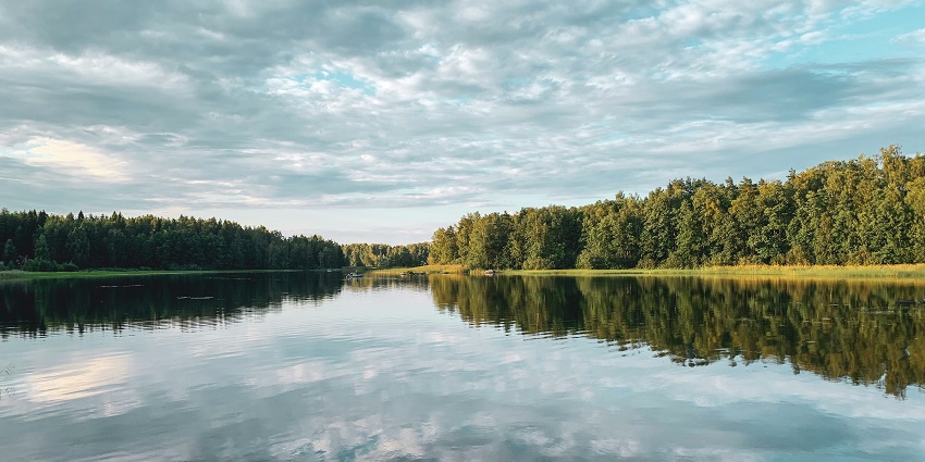 An image of Tilyar Lake, one of the lakes in Haryana with lush greenery and blue waters.