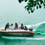 An image of people enjoying a boat ride in the Kankaria lake during the day in Gujarat.