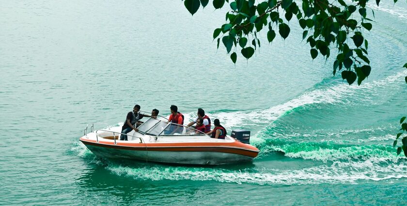 An image of people enjoying a boat ride in the Kankaria lake during the day in Gujarat.