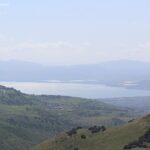 The Sea of Galilee sits among verdant hills in Israel as seen from afar.