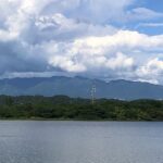 Fluffy clouds hover over the Sukhna Lake with Himalayan Foothills visible in the background