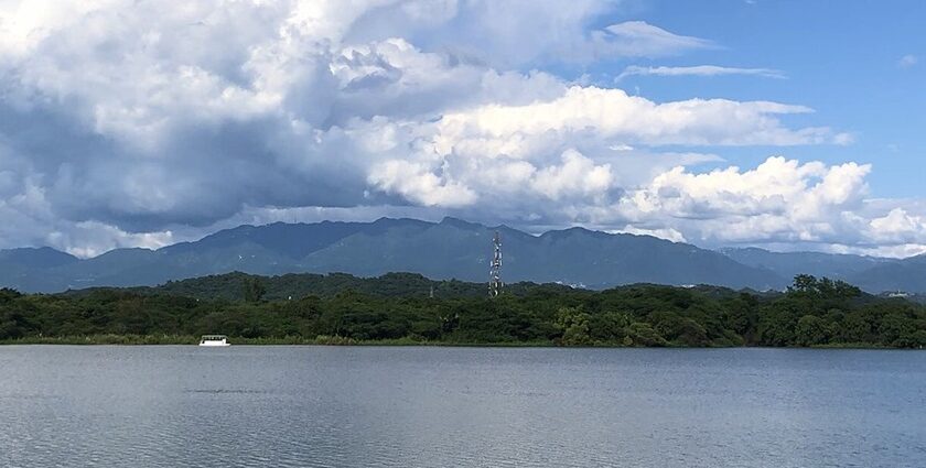 Fluffy clouds hover over the Sukhna Lake with Himalayan Foothills visible in the background