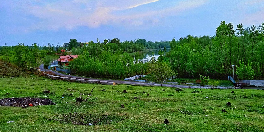 Ganderbal district of Jammu and Kashmir with a small river flowing and distant mountains.