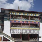 A stunning image of Tawang Monastery in Arunachal Pradesh, surrounded by snow-capped mountains.