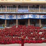 An image of the Sera Jey Monastery nestled against the backdrop of Tibetan mountains.