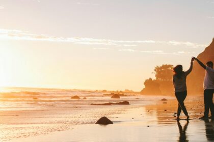 A couple dancing on the beach, sharing a romantic moment this Valentine’s Day in Sydney.