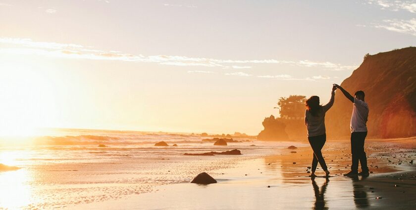 A couple dancing on the beach, sharing a romantic moment this Valentine’s Day in Sydney.