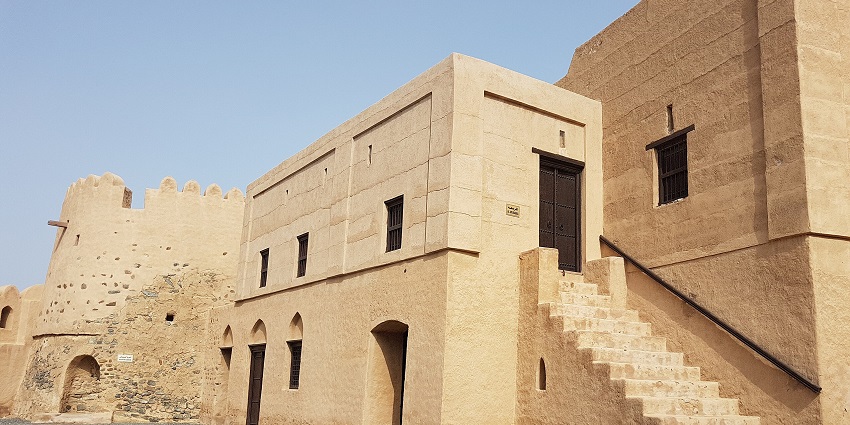 Side view of Fujairah Fort with historic stone walls and stairway leading to the entrance.