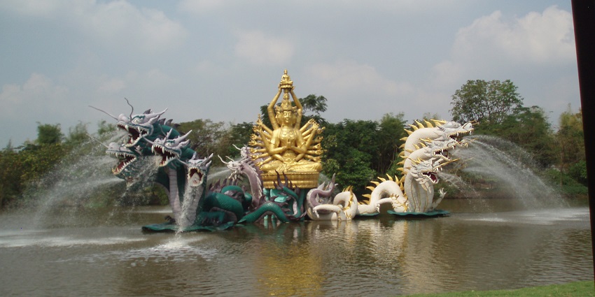 A scenic view of a majestic statue featuring dragons surrounded by azure waters.