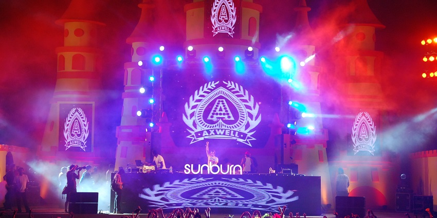 An image of a massive crowd at Goa’s Sunburn Festival, enjoying the music and flashing lights.