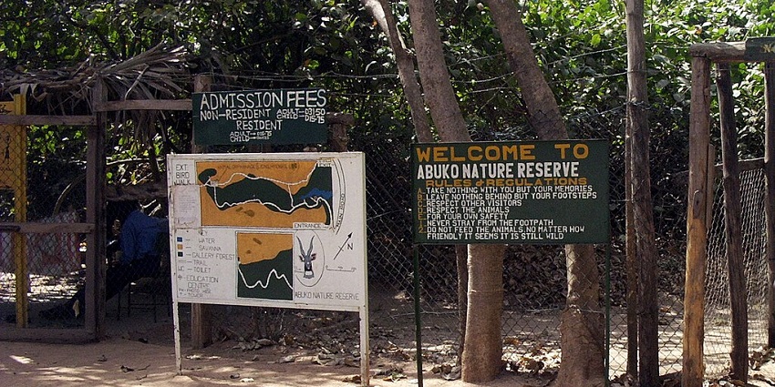 Abuko Nature Reserve with a welcome board and a detailed map of the reserve visible.