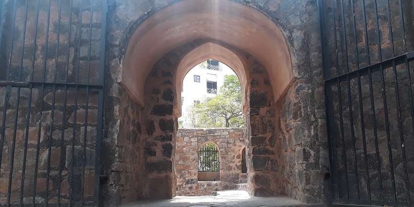 An image of Agrasen Ki Baoli in New Delhi featuring ancient stone steps and arched corridors.