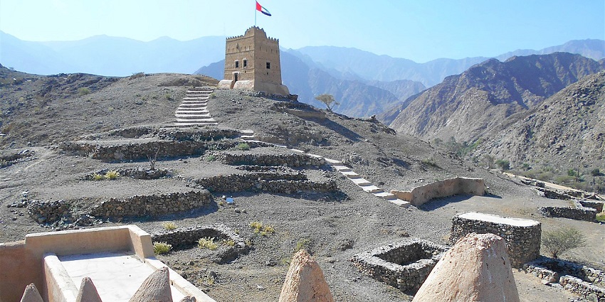 A scenic view of Al-Hayl Castle, showcasing its historic architecture amid rugged landscapes.
