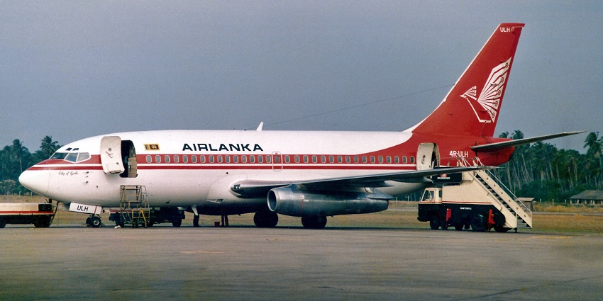 Red and white Boeing 737 aeroplane with stairs connected to the aeroplane gate
