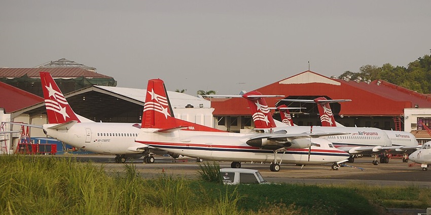 Air Panama aircraft in white and red at Albrook "Marcos A. Gelabert" Airport with green grasses in front