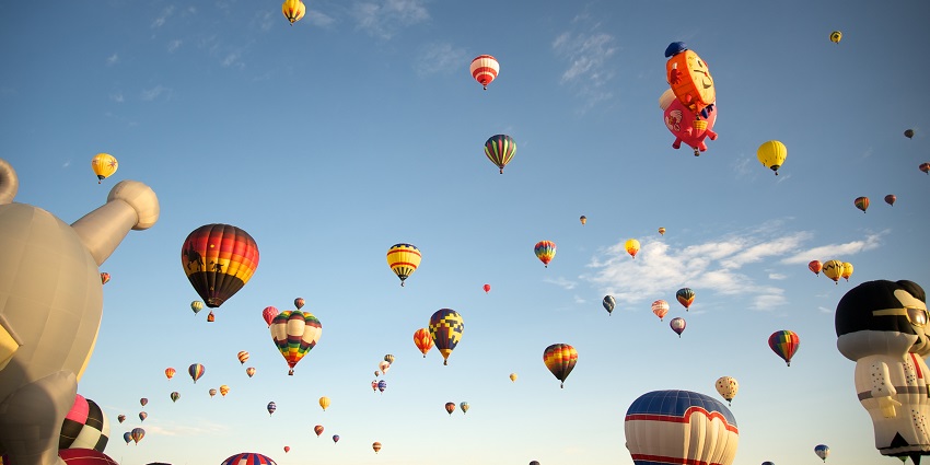 A view of the sky filled with colourful balloons during a festival in autumn season.