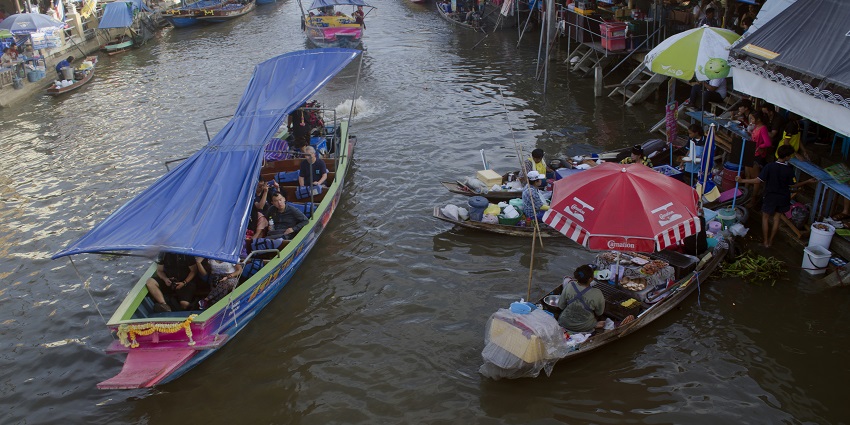 A picture of Amphawa Floating Market with wooden boats selling fresh seafood and local products.