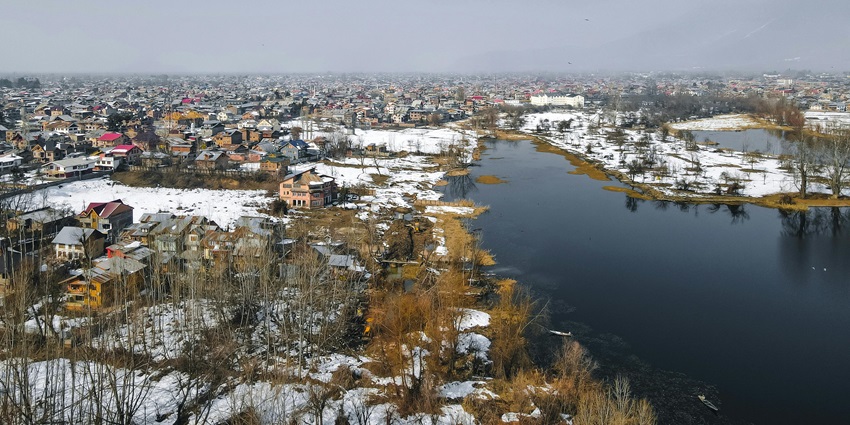 Wetland lake in Srinagar, Kashmir, home to fishermen and lotus harvesters amid fading ecological beauty and urban encroachment.
