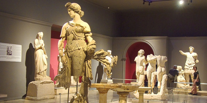 An image of Exhibits of ancient artifacts displayed in Antalya Museum's well-lit gallery.