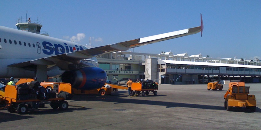 An Airbus parked on an airport runway with the airport terminal in the background