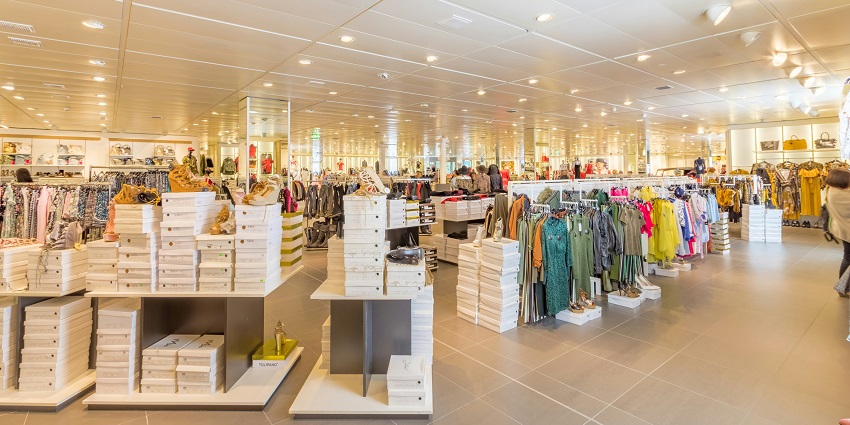 Inside view of a mall with a Swatch store on the left and a man walking in front