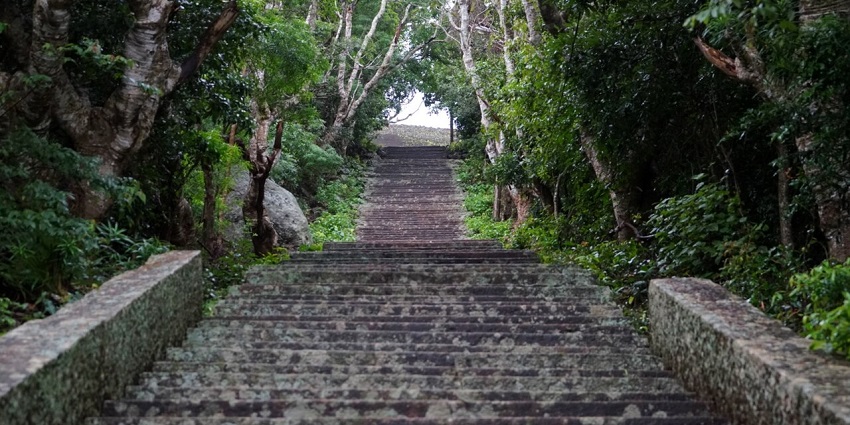 Ancient staircase at Mihintale, lined with lush trees, a serene path to sacred sites