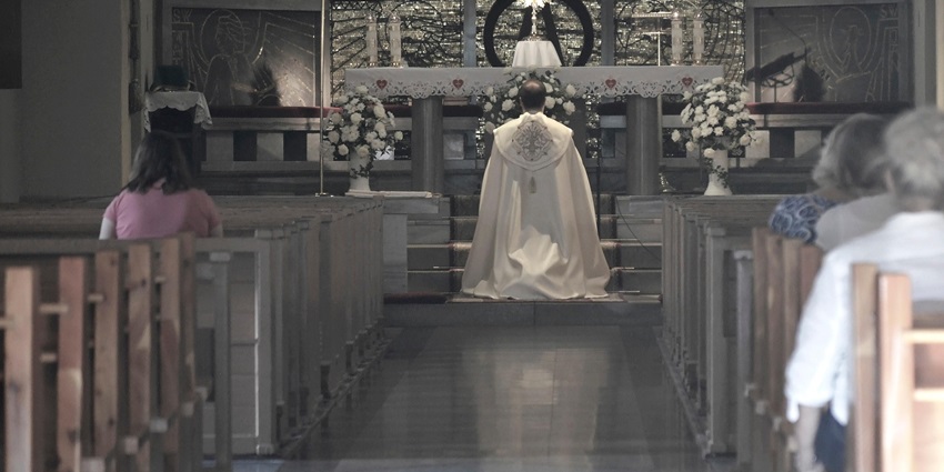 An image showing a priest in a Catholic church holding the Eucharist on Ascension Day.