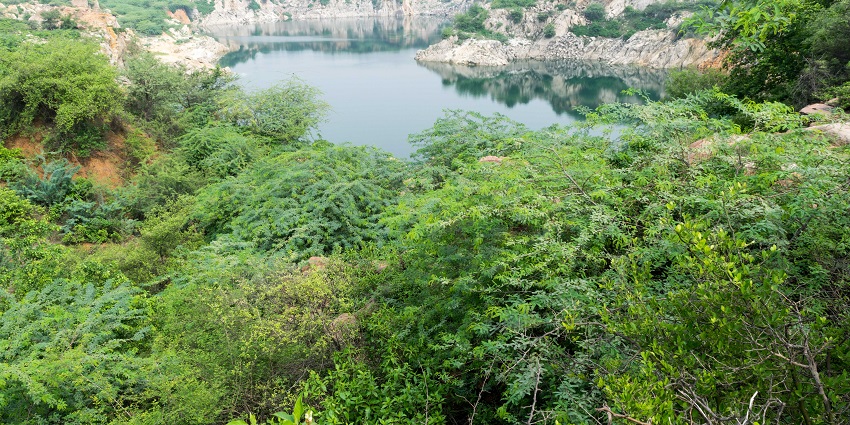 A scenic and attractive lake surrounded by rocky terrain and lush green vegetation