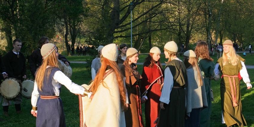 Performers in traditional Lithuanian attire presenting a folklore dance and music show.