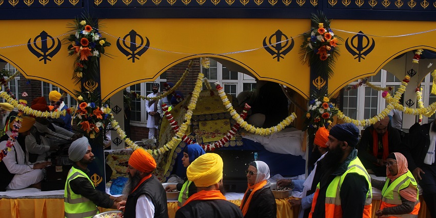 An image of Sikh individuals with bright orange turbans at Baisakhi celebration, one of the most popular agricultural festivals in India.