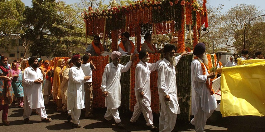 An image of Sikhs in vibrant attire celebrating Baisakhi with Nagar Kirtan and Bhangra dances.