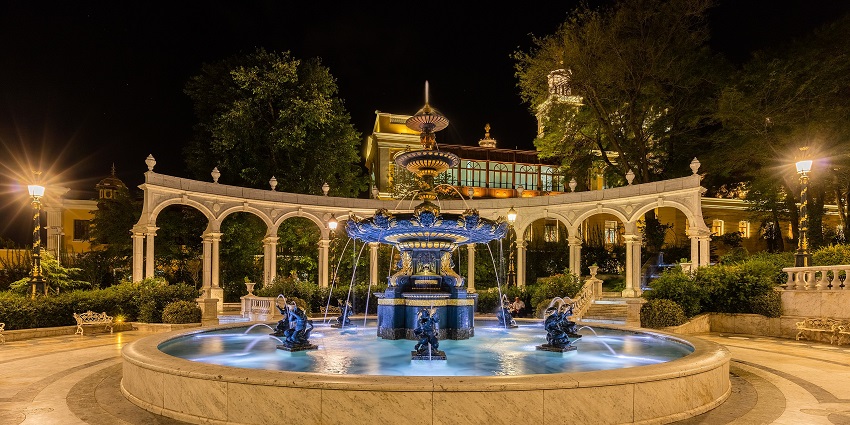 An image of a modern fountain in Baku, Azerbaijan, with a luxurious hotel in background