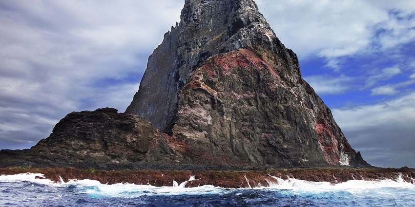 Image of Balls Pyramid, rising from the sea with the clear blue sky in the background