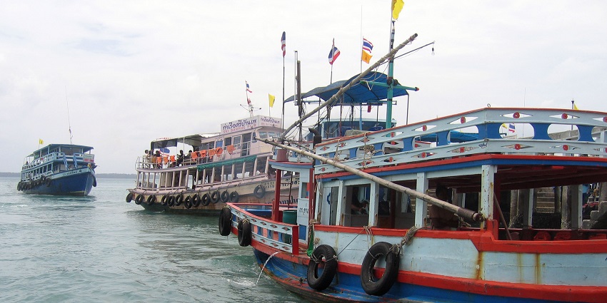 A bustling gateway to Koh Samet with shops, restaurants, and ferry services.