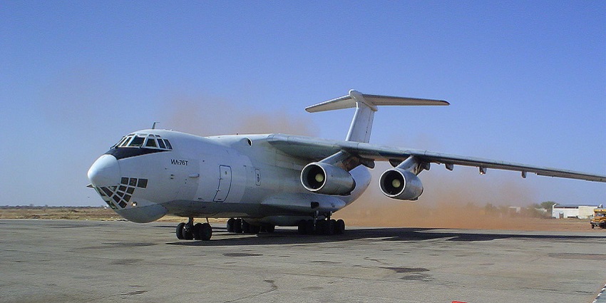 Large commercial aeroplane parked at the runway of an airport and a red cylinder