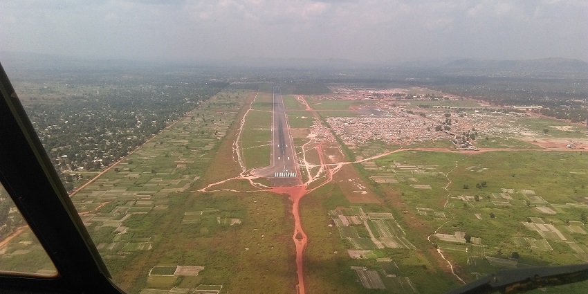 Bangui M'Poko International Airport from above with a long runway and distant buildings