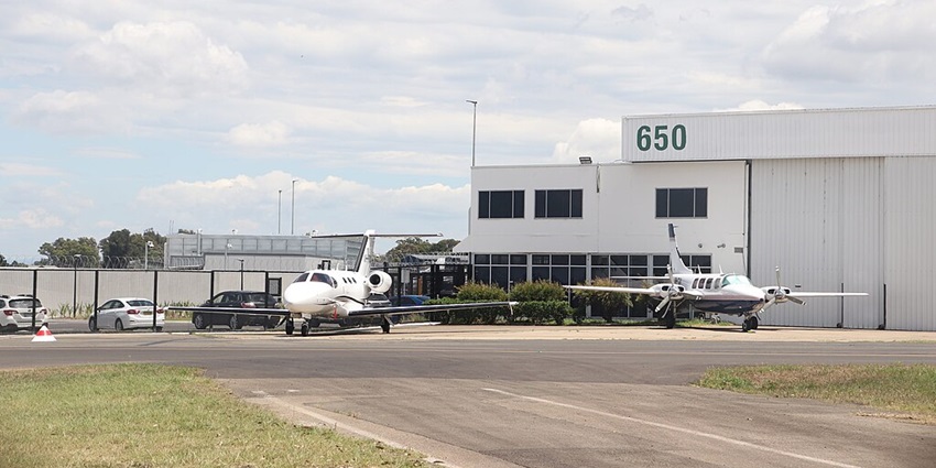 Private aircraft are parking at Bankstown Airport near the hangar and service facilities.