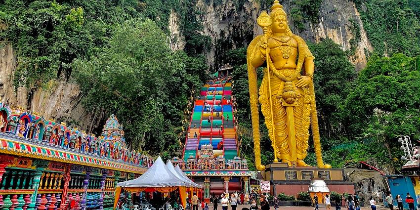 A picture of the famous colourful staircase and the Deity at the Batu Caves