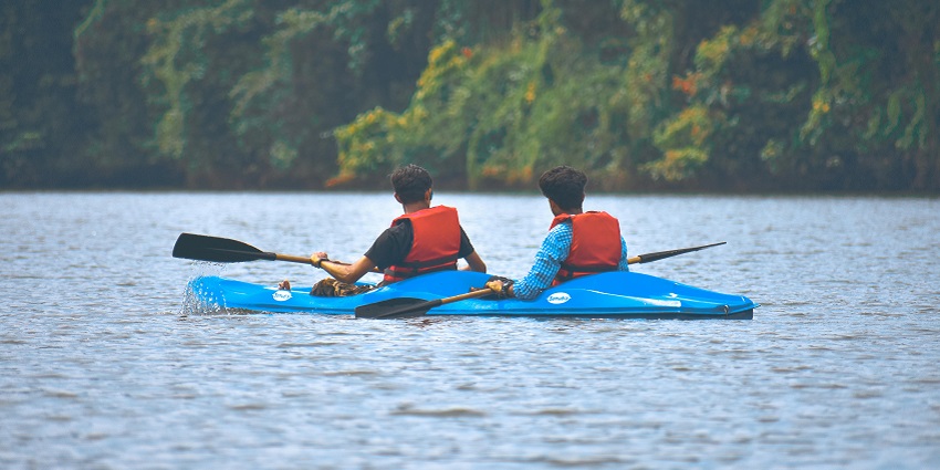 Two people kayaking in a lake with a blue kayak, holding the paddles and safety jackets
Viewers of this file can see comments and suggestions